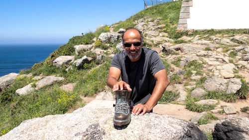 Man keeping boot on rock at mountain