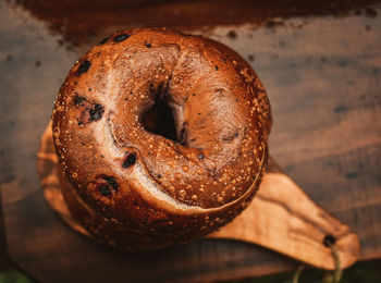 Above stack of blueberry bagels on small olive wood cutting board