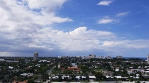 Buildings in city against cloudy sky