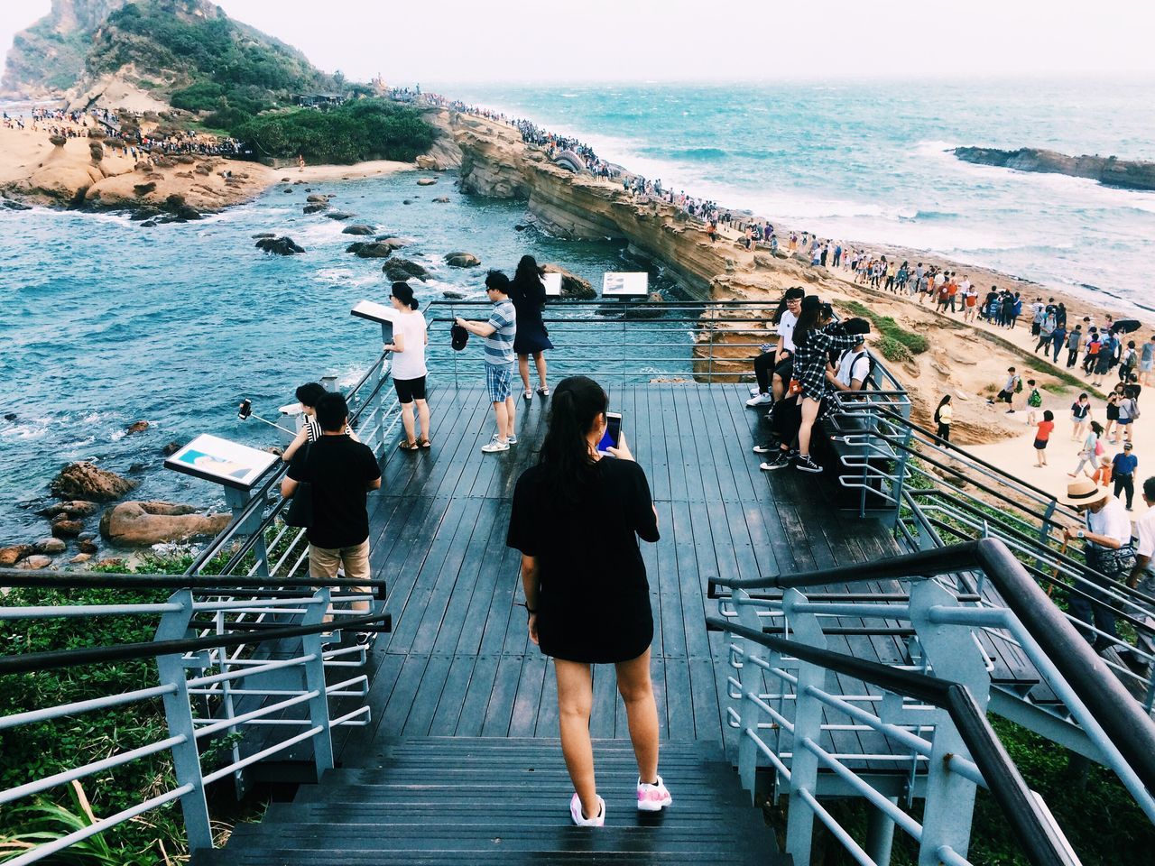 sea, real people, water, railing, lifestyles, horizon over water, high angle view, leisure activity, large group of people, women, day, rear view, men, standing, steps, nature, outdoors, full length, scenics, vacations, beauty in nature, technology, sky, people