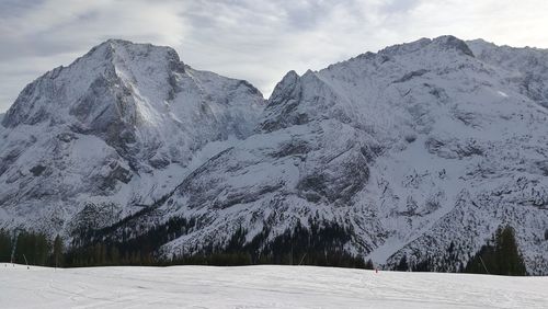 Low angle view of snow mountains against sky