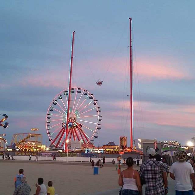 sky, amusement park, leisure activity, amusement park ride, large group of people, arts culture and entertainment, ferris wheel, lifestyles, enjoyment, cloud - sky, fun, person, men, beach, vacations, mixed age range, enjoying, cloud, outdoors