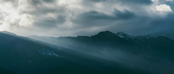 Scenic view of mountains against cloudy sky