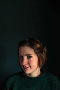 Portrait of beautiful woman against black background