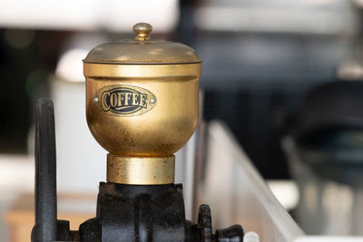 Golden vintage coffee grinder against blurred background