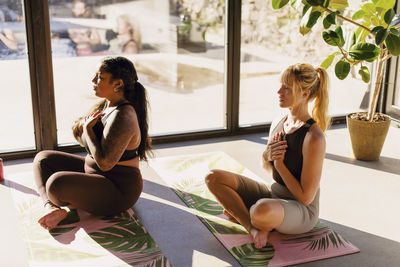 Women doing breathing exercise while sitting on exercise mats at retreat center