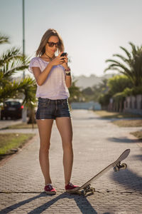 Portrait of woman standing on palm tree