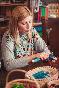 Woman decorating eater eggs while sitting by table