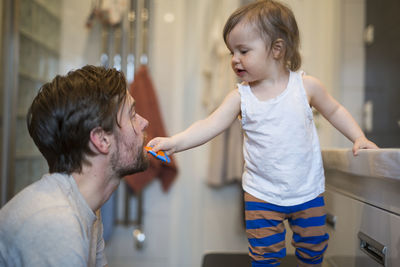 Girl brushing dads teeth