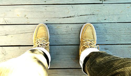 Low section of person walking on wooden floor