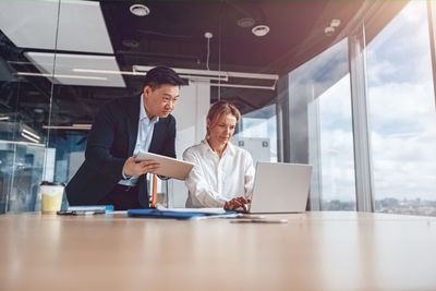 Portrait of businessman using laptop at office