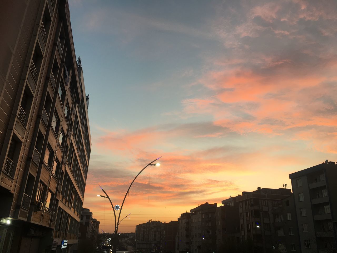 LOW ANGLE VIEW OF BUILDINGS AT SUNSET