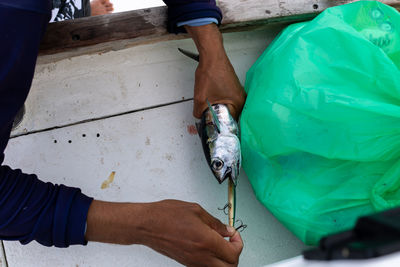 Midsection of man cleaning fish