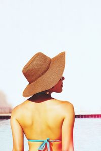 Rear view of shirtless man relaxing on beach