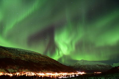 Panoramic view of illuminated mountains against sky at night