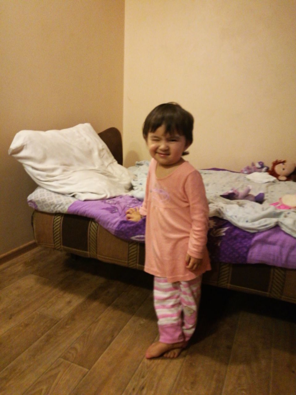 PORTRAIT OF GIRL STANDING ON BED IN BEDROOM