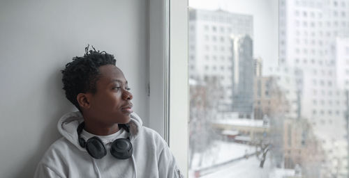 Young male african american student sitting on a windowsill in an educational institution