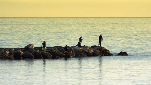 Wide shot of people fishing in sea