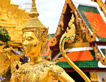 Low angle view of statue against temple building