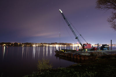 Boats moored at harbor against sky at night