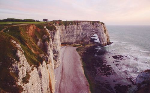 High angle view of rocky cliff by sea at etretat