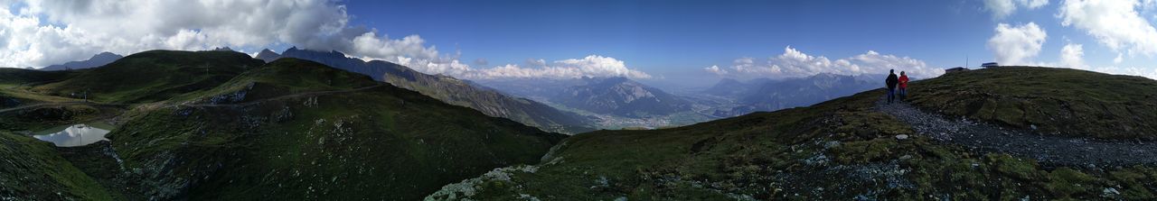 Panoramic view of two people hiking through landscape