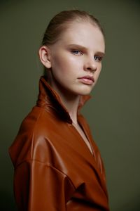 Portrait of young woman against black background