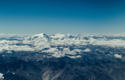 Scenic view of snowcapped mountains against clear blue sky