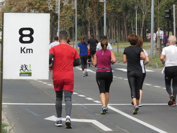 Rear view of people walking on road