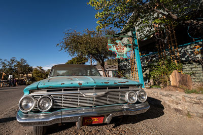 Vintage car against trees against clear blue sky