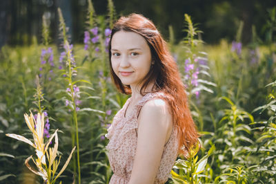 Portrait of smiling beautiful woman standing amidst plants