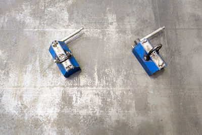 Pair of blue industrial lifting magnets on flat sheet metal surface.