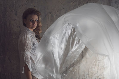 Woman with plastic against wall