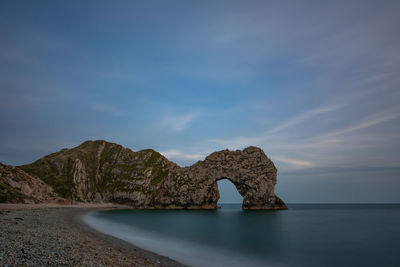 Rock formations on sea shore against sky