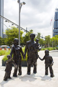 View of children in park against cloudy sky