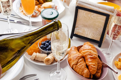 Sunday brunch table. pouring champagne to the glass close-up.