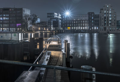 View of illuminated buildings by river