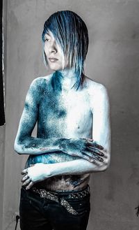 Portrait of young man looking away against wall