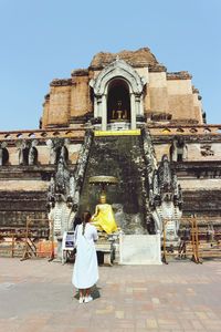 People outside temple against building