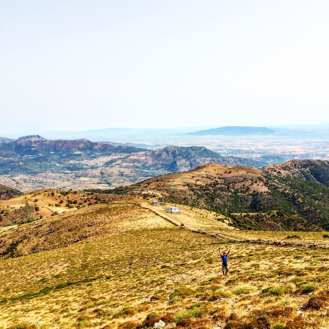 leisure activity, lifestyles, landscape, field, tranquility, tranquil scene, scenics, nature, beauty in nature, grass, unrecognizable person, sky, vacations, day, non-urban scene, outdoors, remote, mountain, casual clothing, idyllic, hill, rural scene, horizon over land, plant