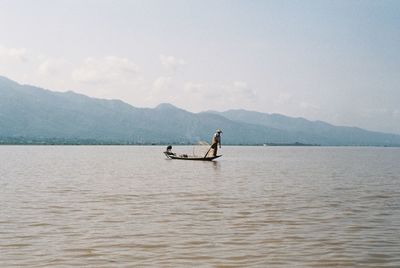 Man on boat in sea against sky