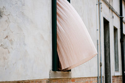 Curtain waving from window of building