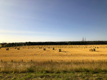 Hay bales on field against sky