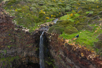 Women sitting against waterfall