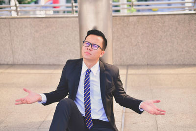 Stressed businessman sitting in city