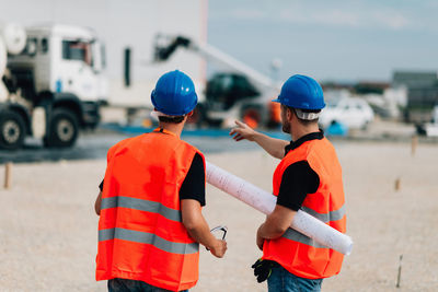 Rear view of construction workers talking outdoors