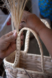 Close-up of hand holding wicker basket