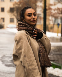 Portrait of young woman standing in city