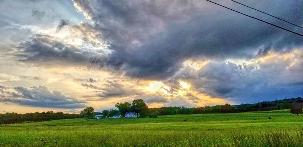 Scenic view of field against dramatic sky