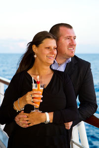 Mature couple looking at sea on ship during sunset